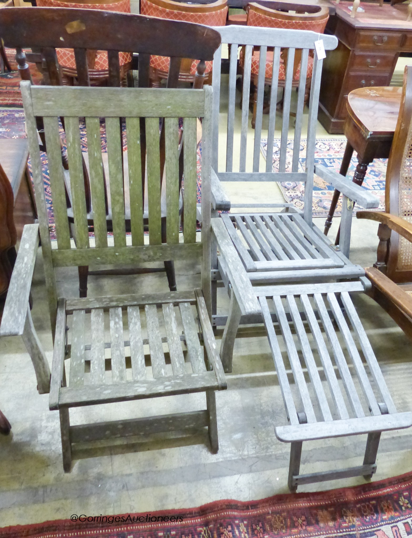 A weathered teak folding steamer chair and a folding garden armchair